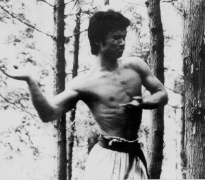 Togashi Yoshimoto, fondateur du Mumonkaï karate, frappant du tranchant de la main sur les arbres durant sa retraite en montagne dans les années 70